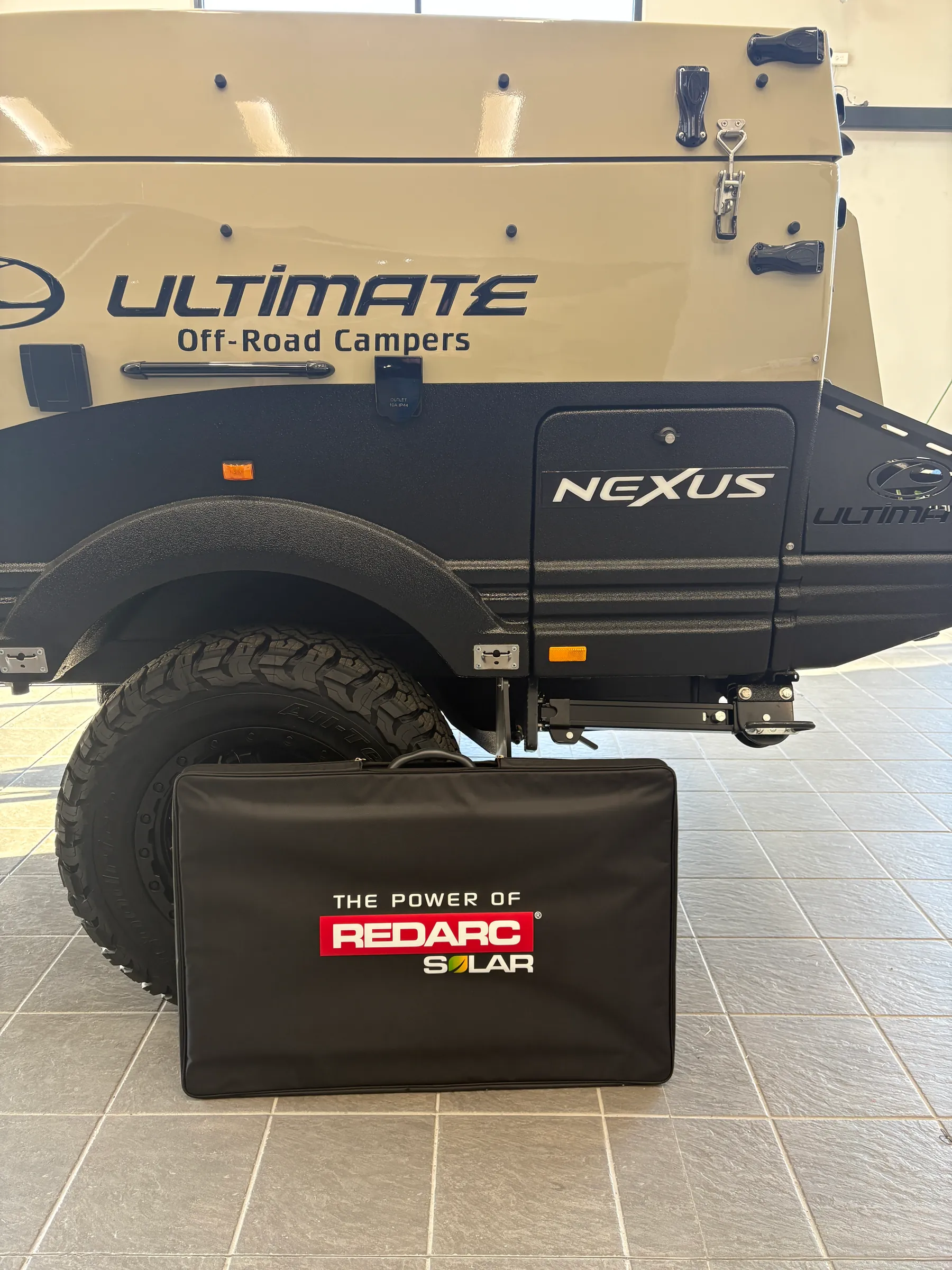 REDARC Solar folding panel beside an Ultimate NEXUS camper
